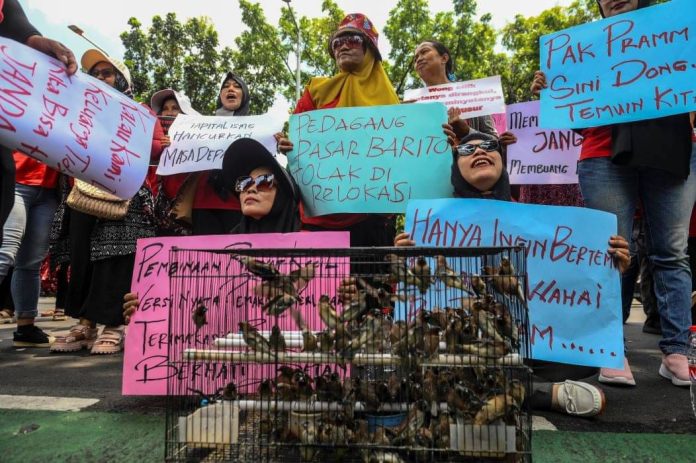 Sejumlah pedagang Pasar Hewan Barito membawa poster saat berunjuk rasa di depan Balai Kota DKI Jakarta, hari ini.(ANTARA FOTO/Hafidz Mubarak A)