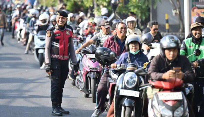 Anggota polisi berjaga di tengah antrean kendaraan yang akan mengisi bahan bakar minyak (BBM) di salah satu SPBU di Denpasar, Selasa (13/10/2026). -ANTARA
